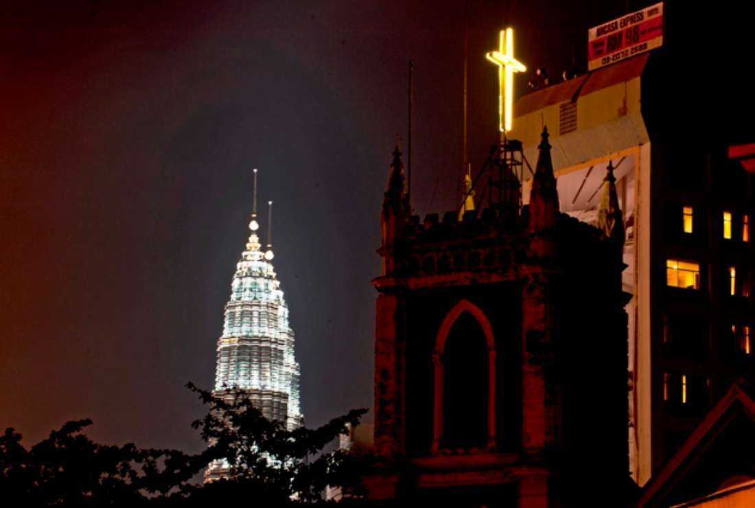A Christian cross pictured on the top of a church next to Malaysia's iconic Twin Towers (left) in downtown Kuala Lumpur, on Aug. 26, 2011. Catholics in and around the federal capital of this Southeast Asian country are facing an acute shortage of cemetery land and funeral parlors
