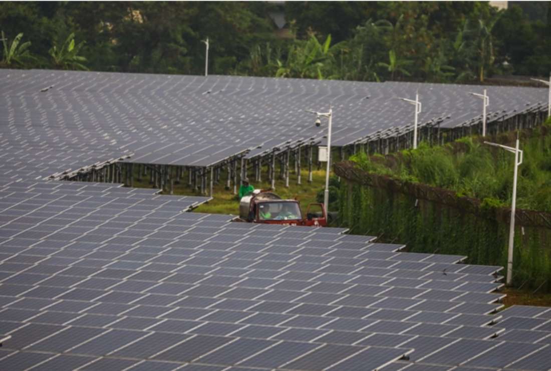 Filipino workers in a utility truck ride past solar panels at a solar energy farm in Valenzuela, suburban Manila on May 28, 2022. The Philippine government is encouraging clean energy power sources across the nation
