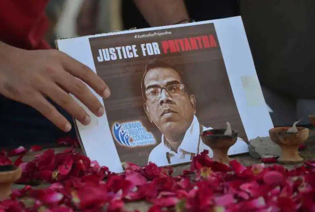 A member of the Human Rights Council of Pakistan pays tribute to late Sri Lankan factory manager Priyantha Kumara Diyawadanage, who was beaten to death and set ablaze by a mob who accused him of blasphemy, in Karachi on Dec. 5, 2021