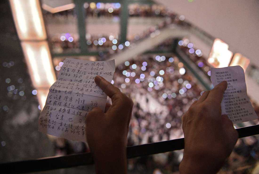 People hold the lyrics as they gather at the shopping mall in the Shatin area of Hong Kong on Sept. 11, 2019, to sing a recently penned protest song titled 'Glory to Hong Kong’ which has been gaining popularity in the city