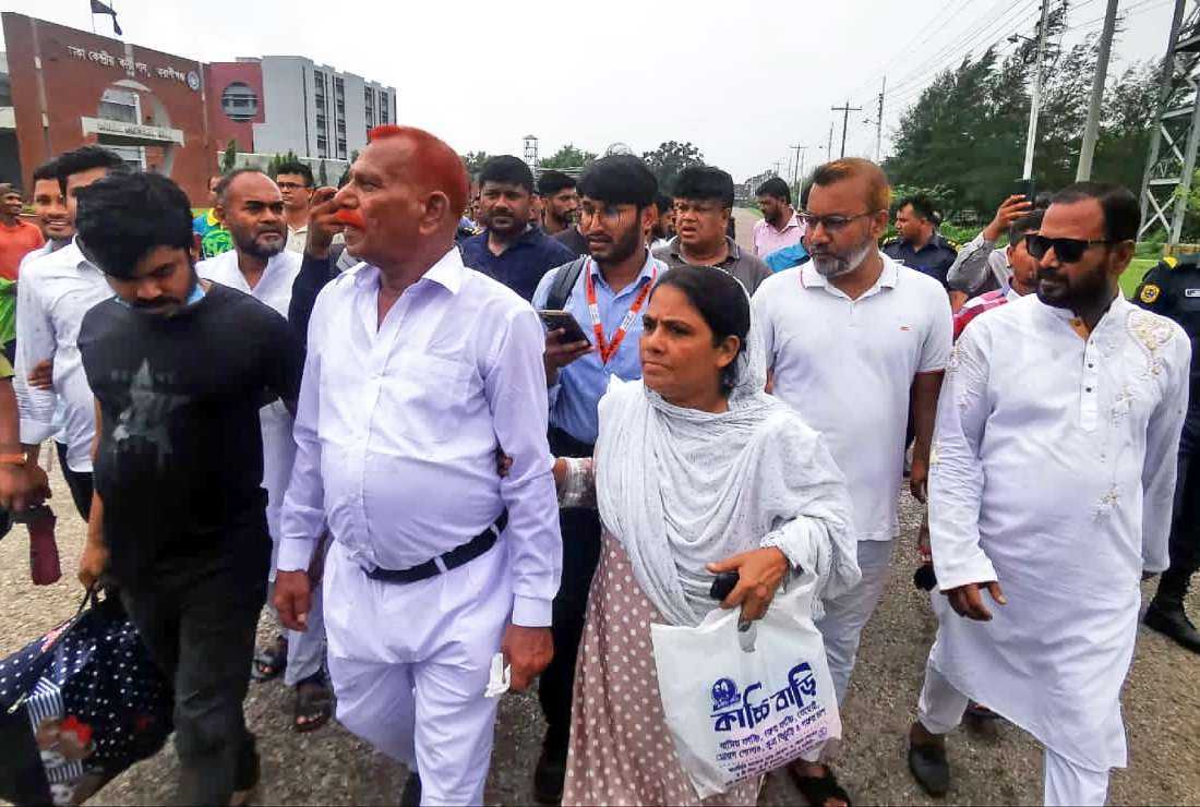 Bangladeshi hangman Shahjahan Bhuiyan (second from left) walks out from jail after his release in Keraniganj on June 18
