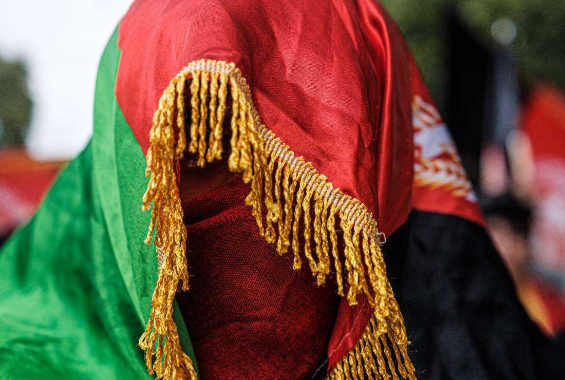 An Afghan woman is seen covered in the Afghanistan national flag