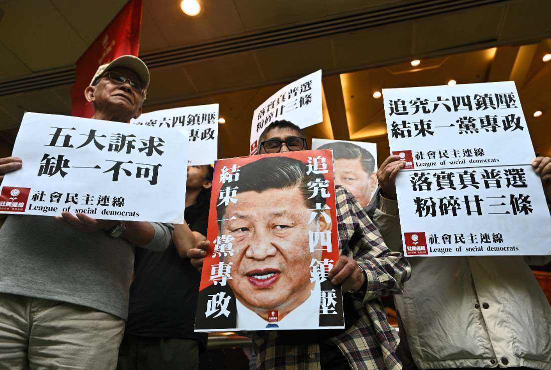 Pro-democracy activists chant slogans and display placards of Chinese President Xi Jinping during a protest before trying to board a ferry to Macau, in Hong Kong on Dec. 18, 2019