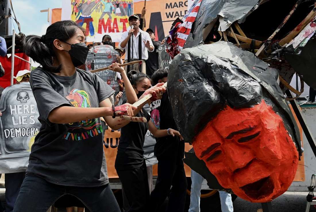 Protesters destroy an effigy of Philippine President Ferdinand Marcos Jr during a rally on Feb. 25 marking the 37th anniversary of the 'People Power' revolution, which ousted Marcos Jr's dictator father and sent the family into exile, on Epifanio de los Santos Avenue, or EDSA, in Quezon City