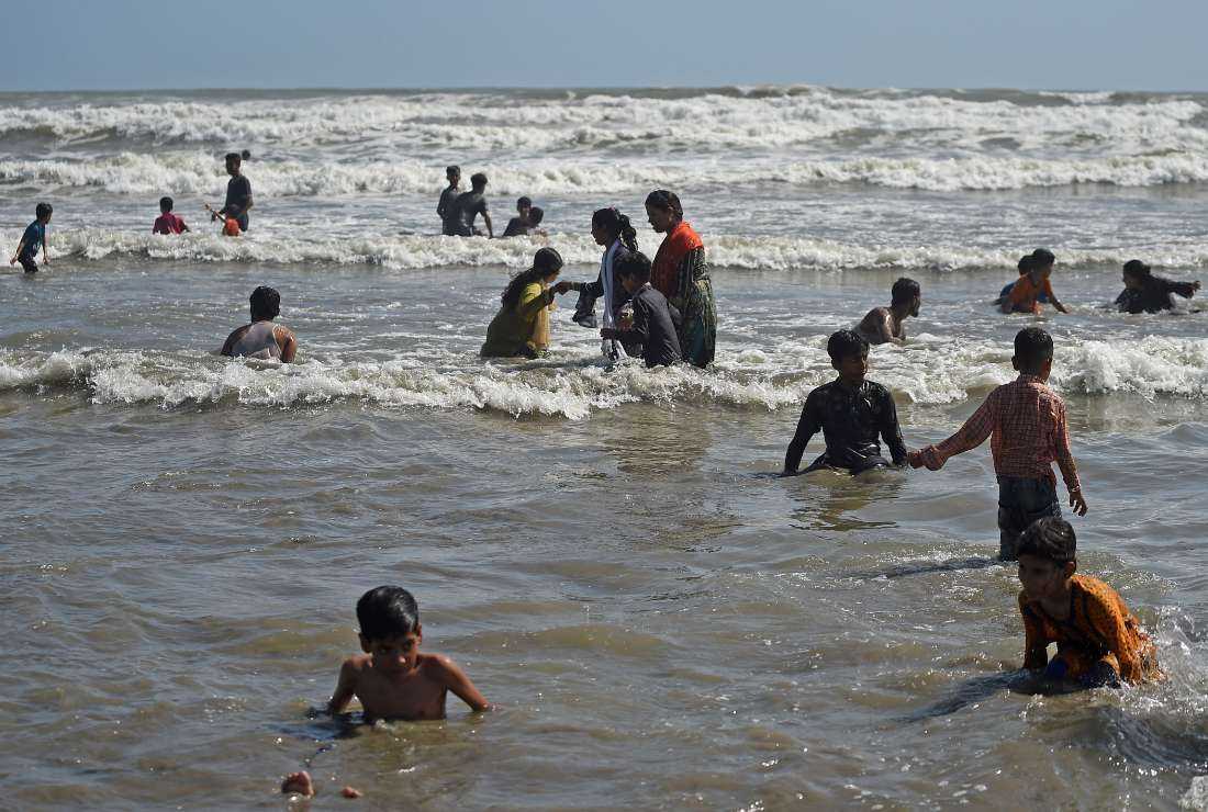 People bathe along Seaview Beach in Karachi on June 11. Heavy rains followed by strong winds killed at least 27 people, including eight children, in northwest Pakistan, officials said