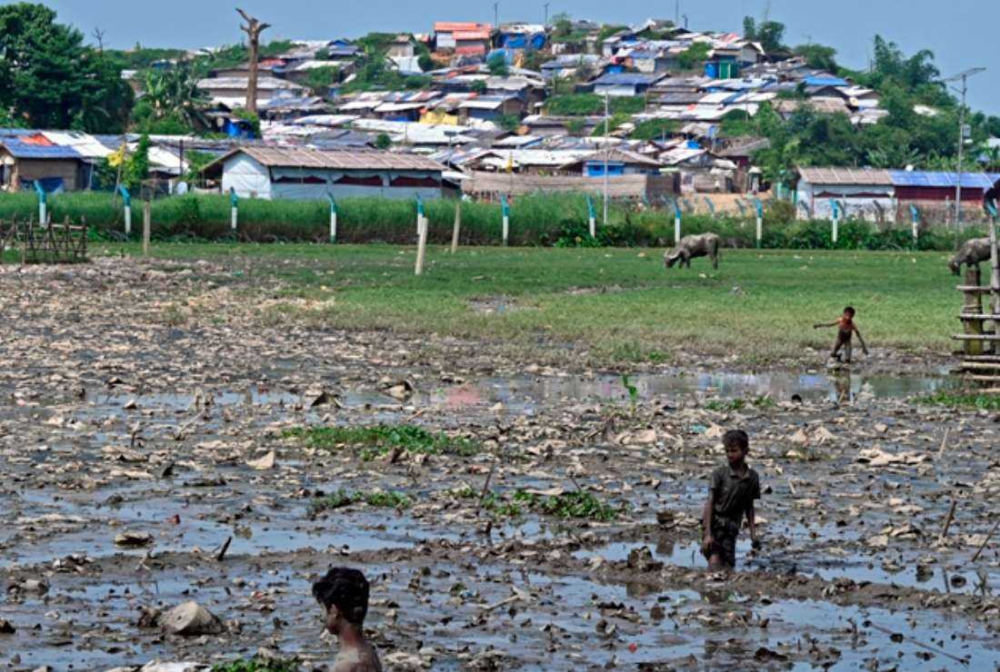Rohingya refugees stand amid garbage at the community's agricultural land at Kutupalong refugee camp in Ukhia, Bangladesh, on Sept. 29, 2022. Health officials warn that the cramped refugee camps in Cox's Bazar face the threat of a severe dengue outbreak this year