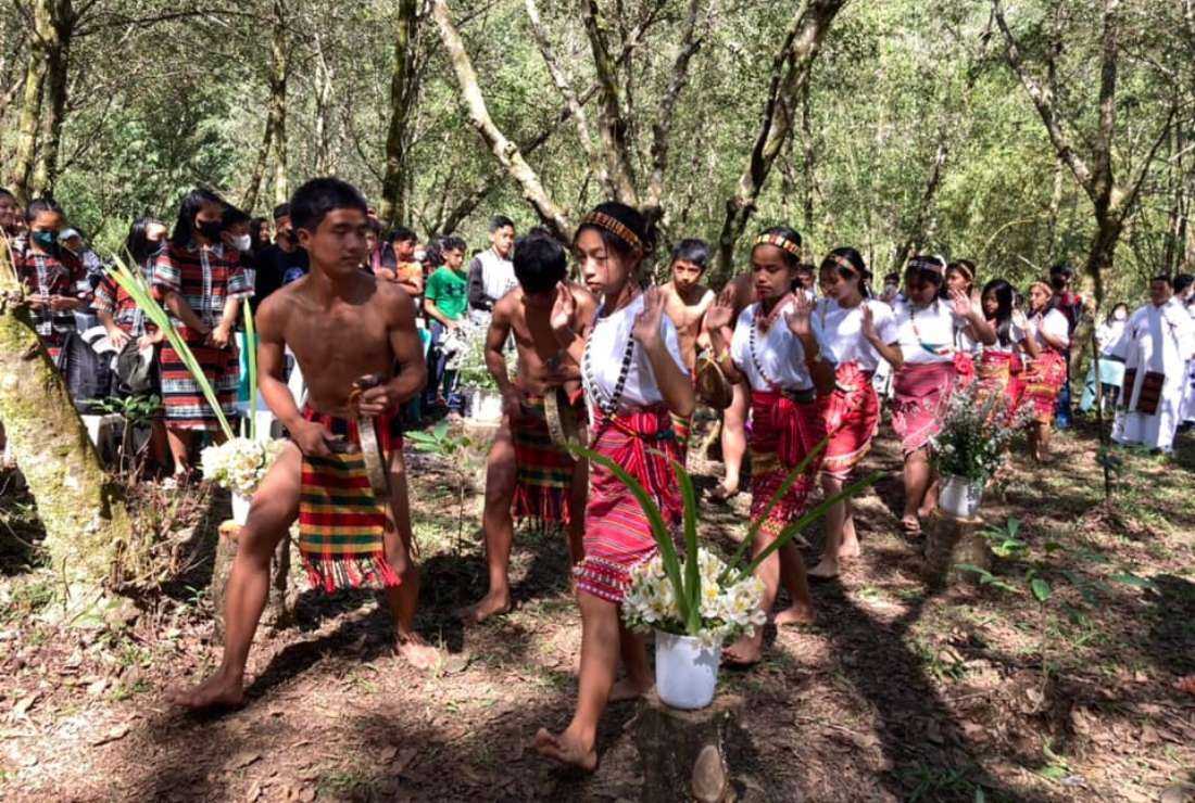 Youth from the Igorot tribe of the Philippines dressed in traditional attire perform a folk dance during Holy Mass at a village